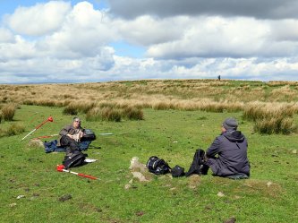 Archaeology Group members settle for lunch on some convenient flat rocks after a fruitless morning search for archaeology. Another member scours the surrounding rushes trying to find his rucksac.